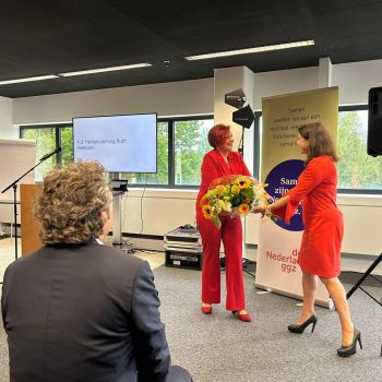 Ruth Peetoom neemt bloemen in ontvangst tijdens de ALV
