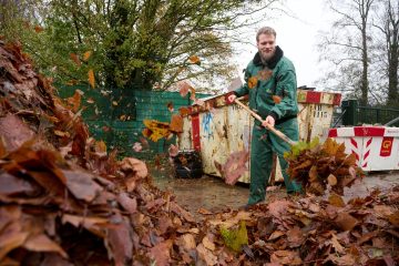 Deelnemer Groendienst GGZ NHN schept bladeren op