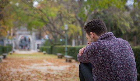 Pijnzende man op bankje