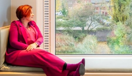 Ruth zit op een vensterbank in ggz instelling en kijkt naar buiten