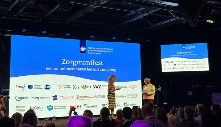 Spreker op podium bijeenkomst Zorgmanifest