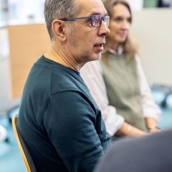 Man praat met begeleider