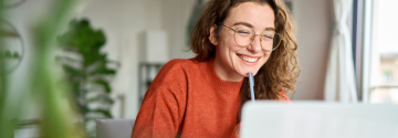 Vrouw kijkt website achter laptop