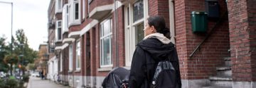 Jonge vrouw loopt door een woonwijk in de stad