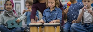 Kinderen met muziekinstrumenten en juf