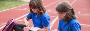 Lunchende meisjes op atletiekbaan