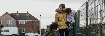 Vrouw loopt met kinderen op straat