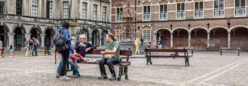 Mensen zitten op bankje in het binnenhof Den Haag