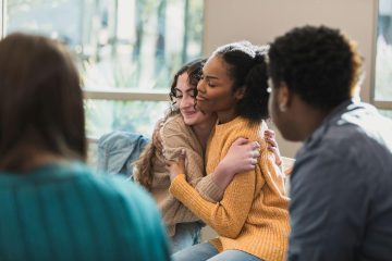 Twee vrouwen omhelsen elkaar en glimlachen