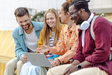 Groep studenten kijken naar latop en lachen