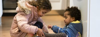 twee kinderen trekken hun schoenen aan