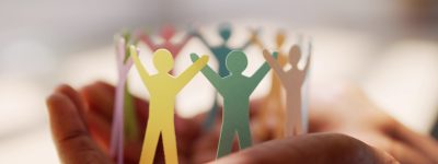 Papieren poppetjes die handen vast houden