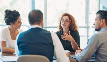 4 mensen aan tafel in overleg
