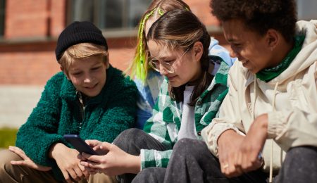 Drie jongeren met telefoon buiten