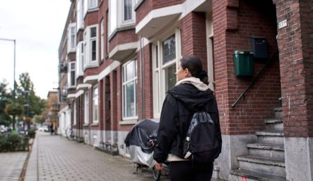 Jonge vrouw loopt door een woonwijk in de stad