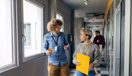 Man en vrouw kletsen en lopen door een gang