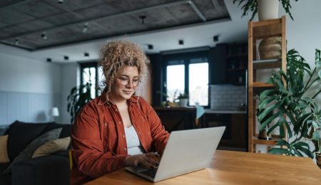 Vrouw is druk aan het werk achter laptop