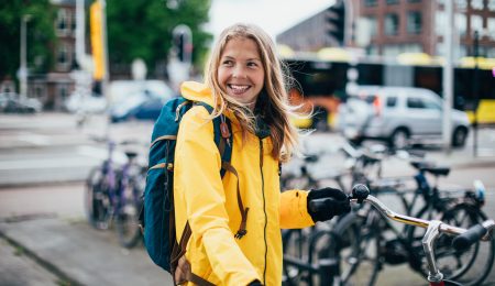 Vrouw kijkt vrolijk met fiets aan de hand i Stock 1149259648