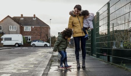 Vrouw loopt met kinderen op straat