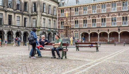 Mensen zitten op bankje in het binnenhof Den Haag