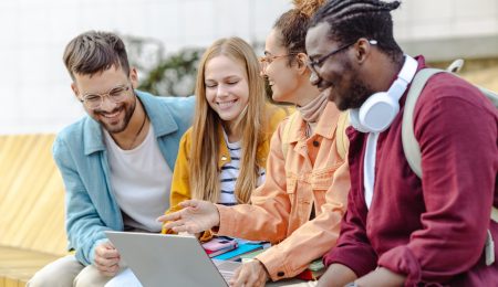 Groep studenten kijken naar latop en lachen