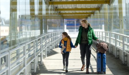 Vrouw met dochter lopen met koffer
