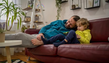Man zit op de bank met kind