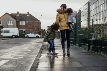 Vrouw loopt met kinderen op straat