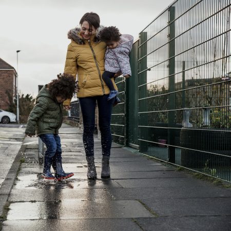Vrouw loopt met kinderen op straat